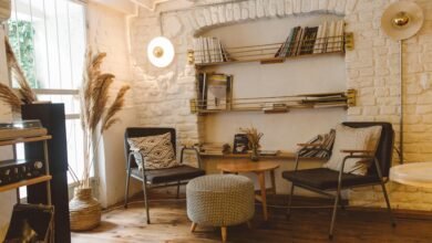Inviting modern rustic living room featuring armchairs, an ottoman, and a stylish bookshelf.