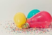 Vibrant colorful balloons surrounded by confetti, perfect for party celebrations.