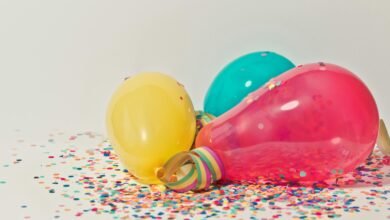 Vibrant colorful balloons surrounded by confetti, perfect for party celebrations.