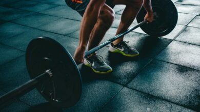 Man performing a deadlift exercise in a gym, demonstrating strength and fitness.